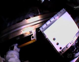 NASA astronaut Rick Mastracchio holds a failed backup computer in this vide from his helmet camera during a spacewalk outside the International Space Station on April 23, 2014. The spacewalk's goal was to replace the dead computer with a spare.