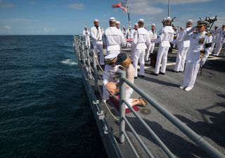 US Navy Lieutenant Commander Paul Nagy, USS Philippine Sea, and Carol Armstrong, wife of Neil Armstrong, commit the cremains of Neil Armstrong to sea during a burial at sea service held onboard the USS Philippine Sea (CG 58), Friday, Sept. 14, 2012, in the Atlantic Ocean. Armstrong, the first man to walk on the moon during the 1969 Apollo 11 mission, died Saturday, Aug. 25. He was 82.