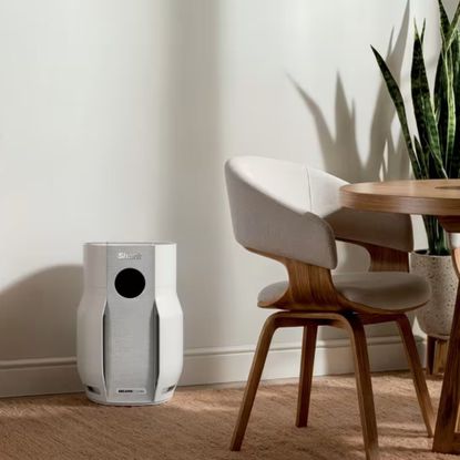 Shark BreatheClear with NeverChange6 sitting on floor in a dining room, next to a dining chair and a plant