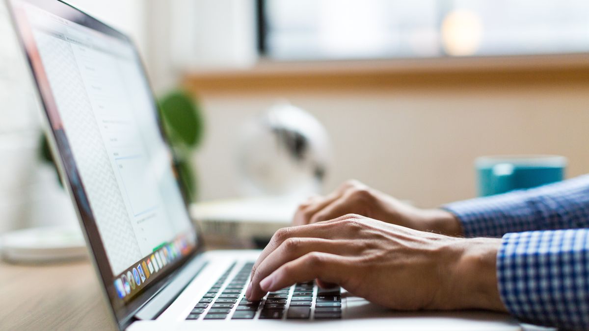 A person typing on a laptop