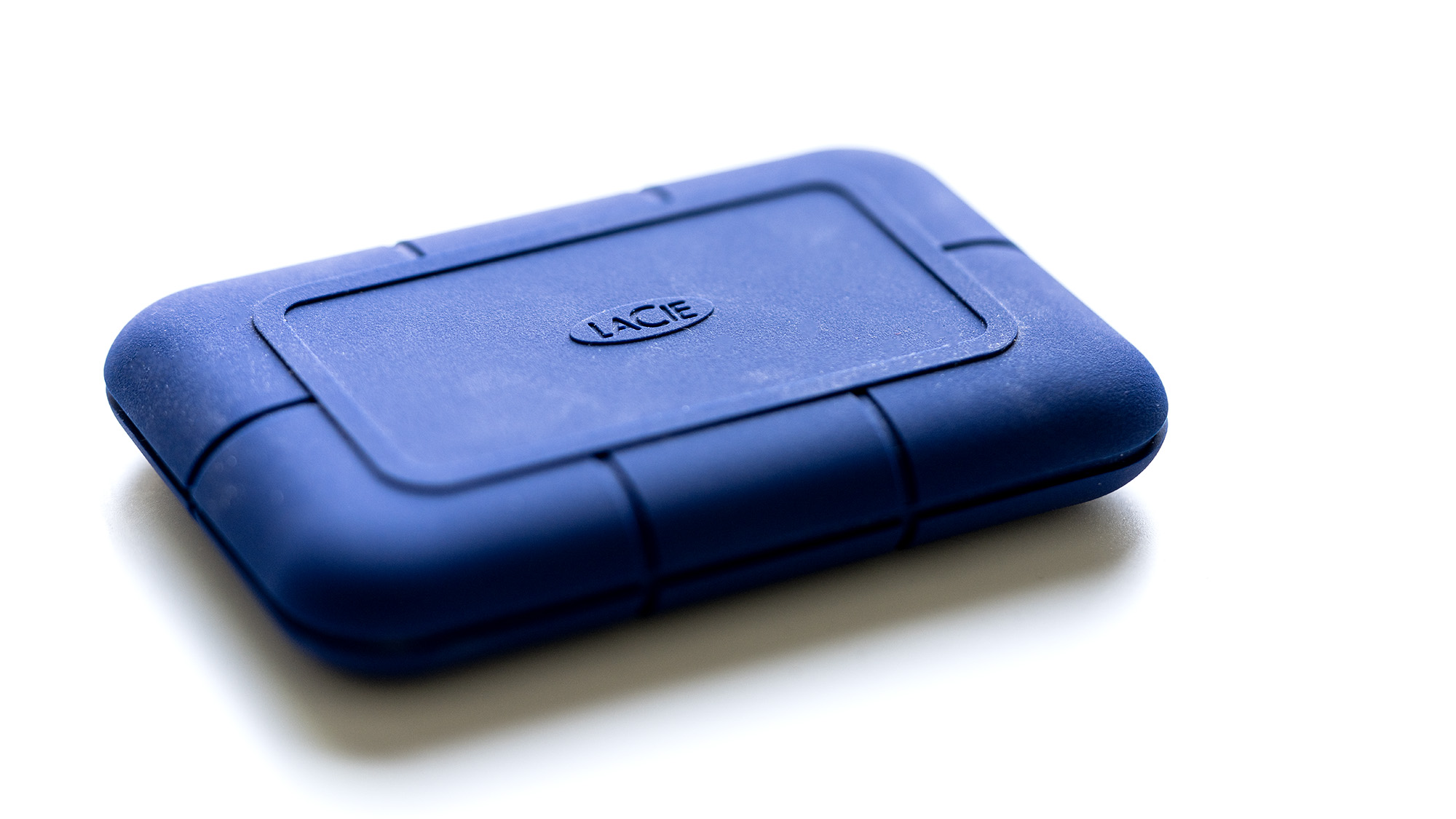 The LaCie Rugged Pro 5 in blue on a laptop and on a white background.