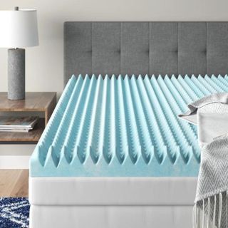 Egg crate mattress topper on bed in styled room 