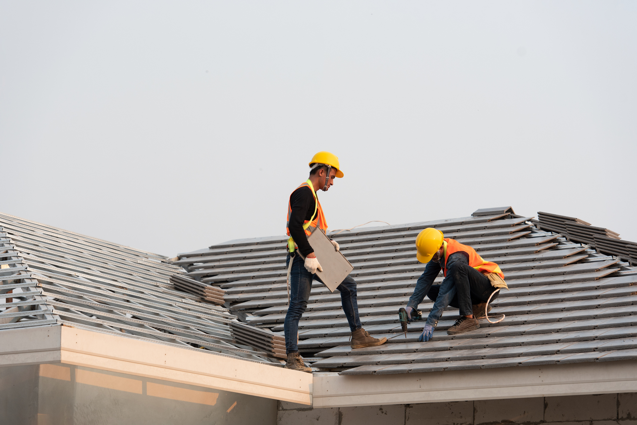 Roofers are installing a new roof on a home. 