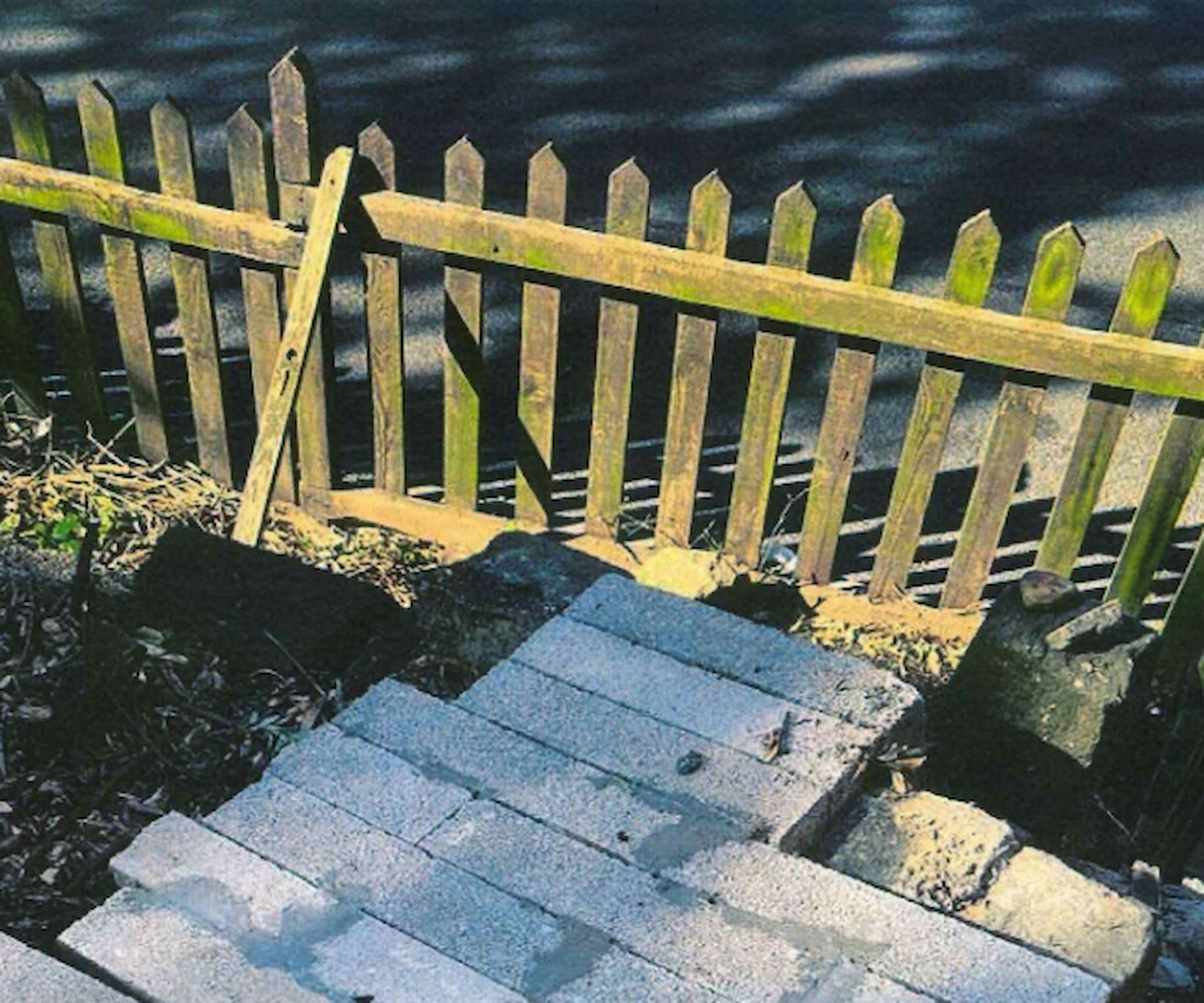 A small picket fence and concrete blocks