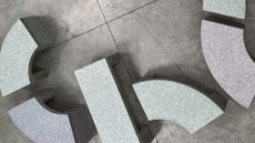 Benches photographed from above, arranged into a shape that is reminiscent of the GBP symbol