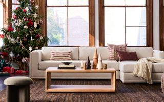 A cream colored sofa with a Christmas tree