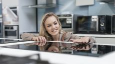 Woman caressing induction hob in a kitchen showroom