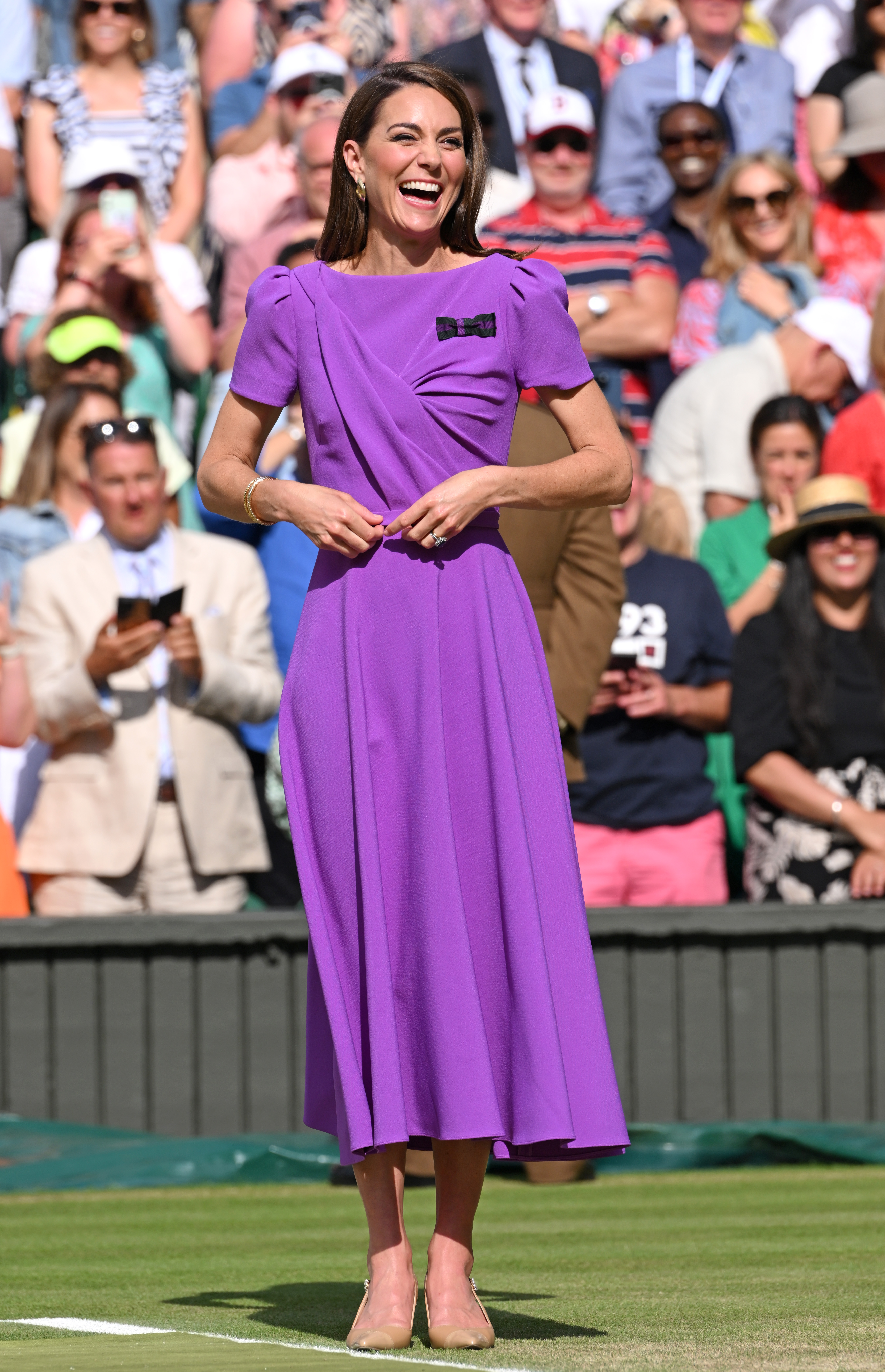 Kate Middleton wearing a purple dress laughing at Wimbledon