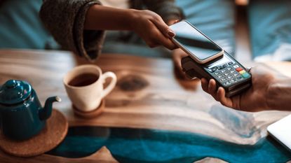 woman paying for coffee with phone