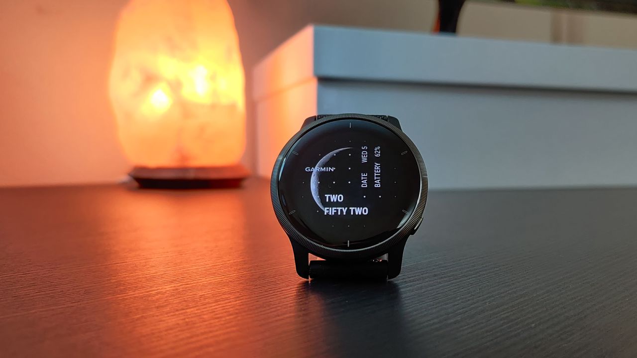 Garmin Venu 2 fitness watch placed on a table in front of a salt lamp