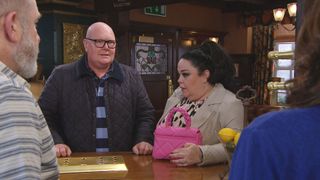 Mandy Dingle looks worried next to Paddy in the pub. 