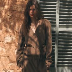 Woman wears brown linen shirt with matching trousers