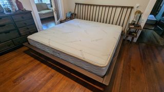 The Saatva Memory Foam Hybrid mattress on a bed in a bedroom