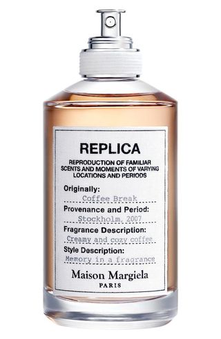 Maison Margiela Replica Coffee Break Eau De Toilette in tall golden bottle with white label with black text and silver spray pump wrapped in white rope 