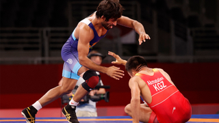 yrgyzstan's Ernazar Akmataliev (red) wrestles India's Bajrang Bajrang in their men's freestyle 65kg wrestling early round match during the Tokyo 2020 Olympic Games at the Makuhari Messe in Tokyo on August 6, 2021