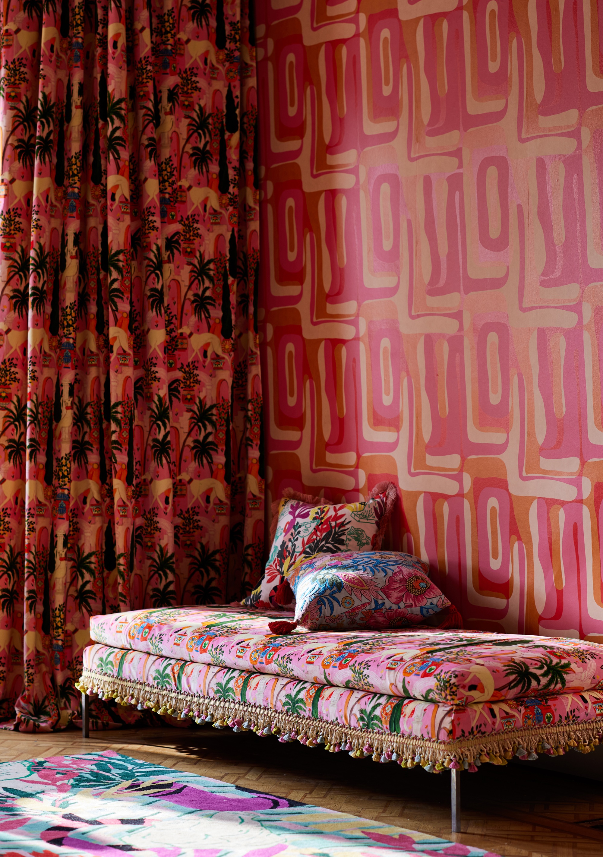 a pink room with bold patterned wallpaper, curtains and a daybed