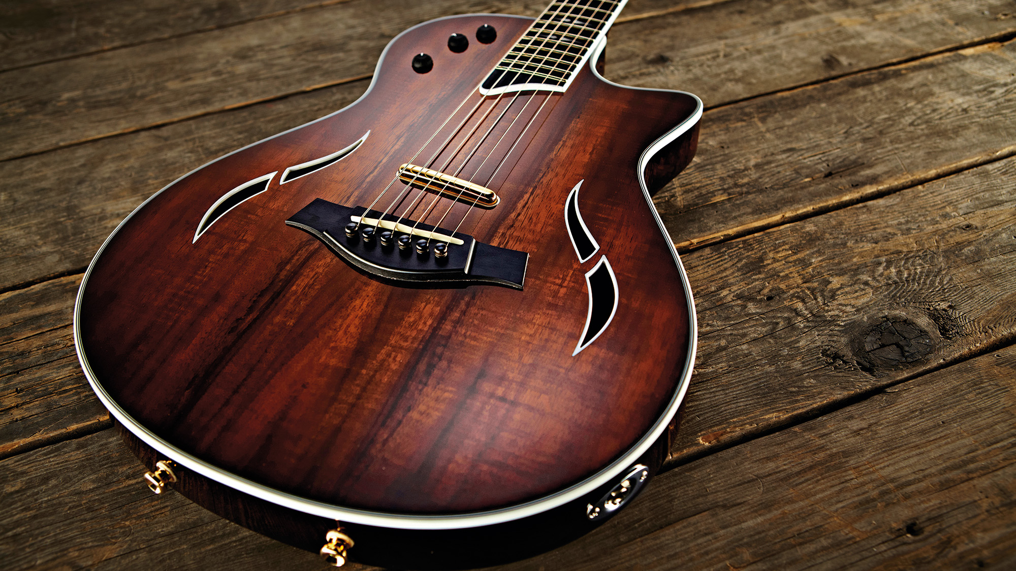 A Taylor T5Z Custom electro-acoustic guitar on a wooden floor.