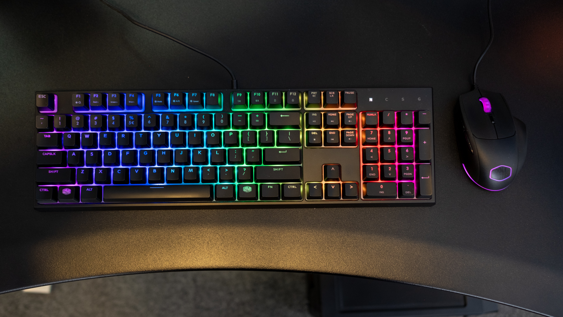 Black keyboard and mouse with colored lighting featuring purple, blue, green, yellow, orange and pink to highlight the keys.