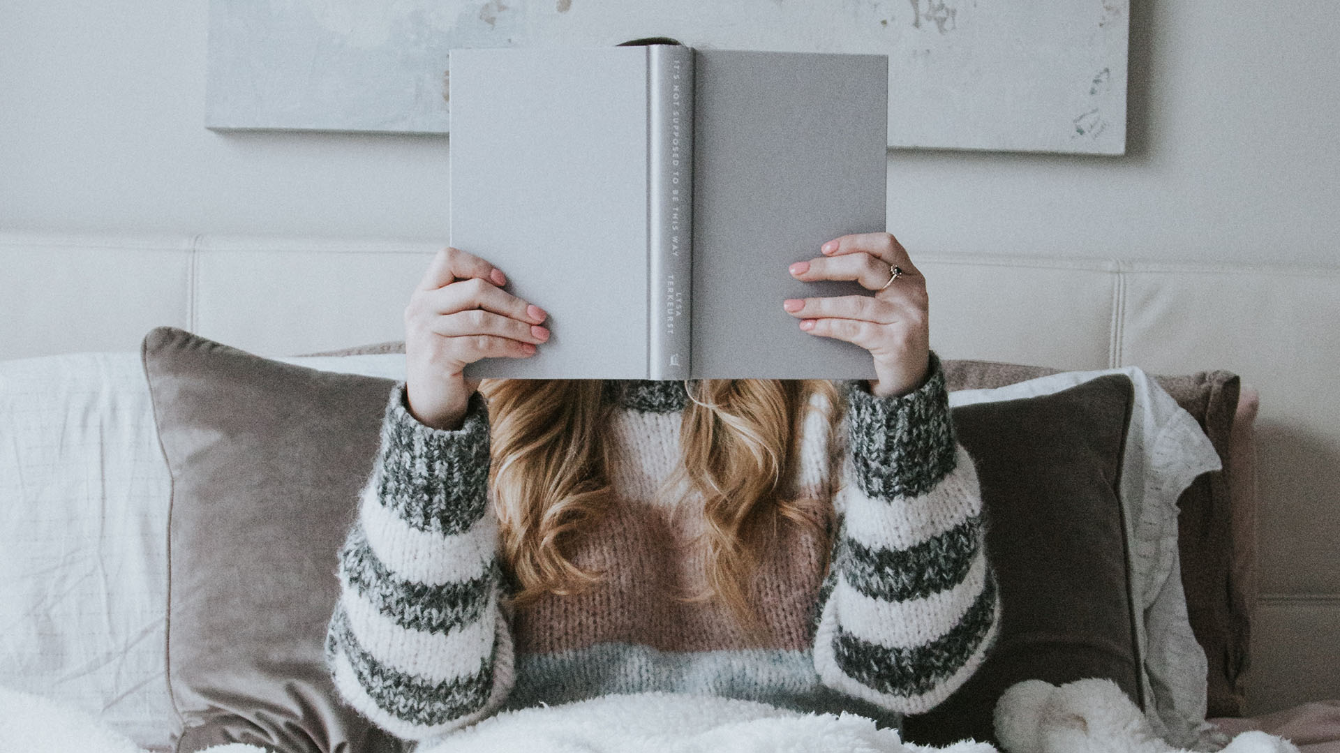 woman in bed reading a book