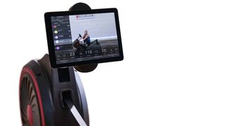 Echelon Row smart rowing machine, arm holding tablet displaying Echelon app