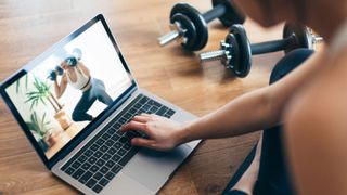 woman weights workout on laptop