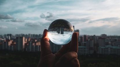 A crystal ball reflects a city skyline.