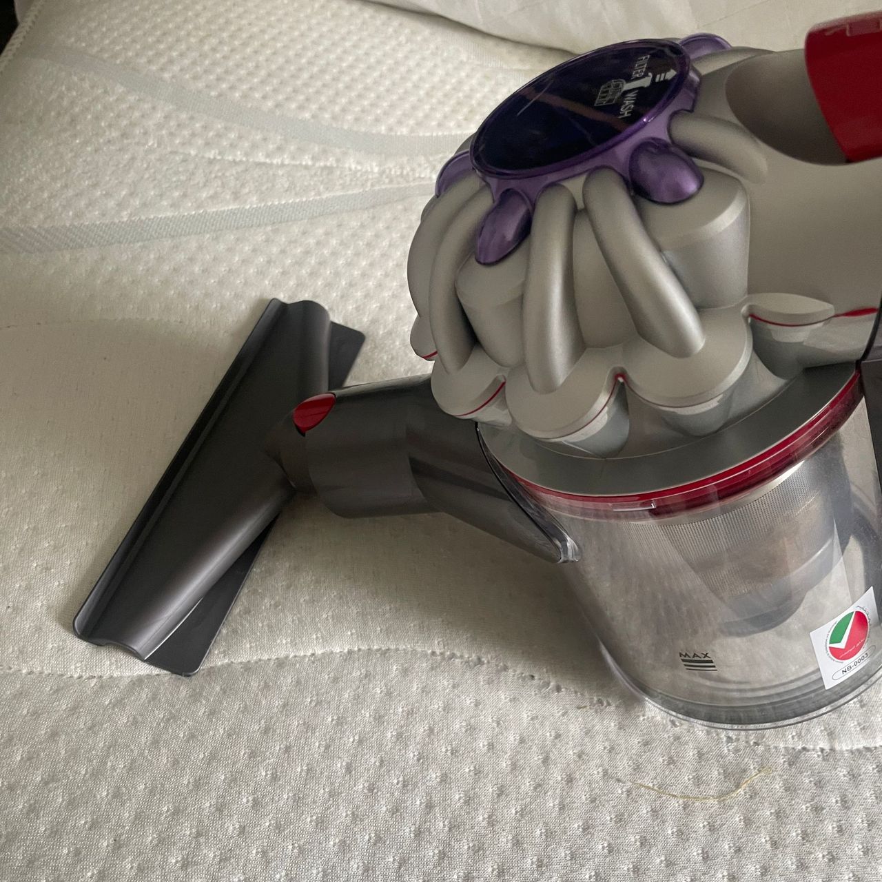 Using the Dyson V8 Absolute mattress tool on a white mattress
