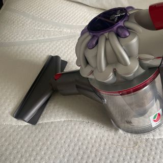 Using the Dyson V8 Absolute mattress tool on a white mattress