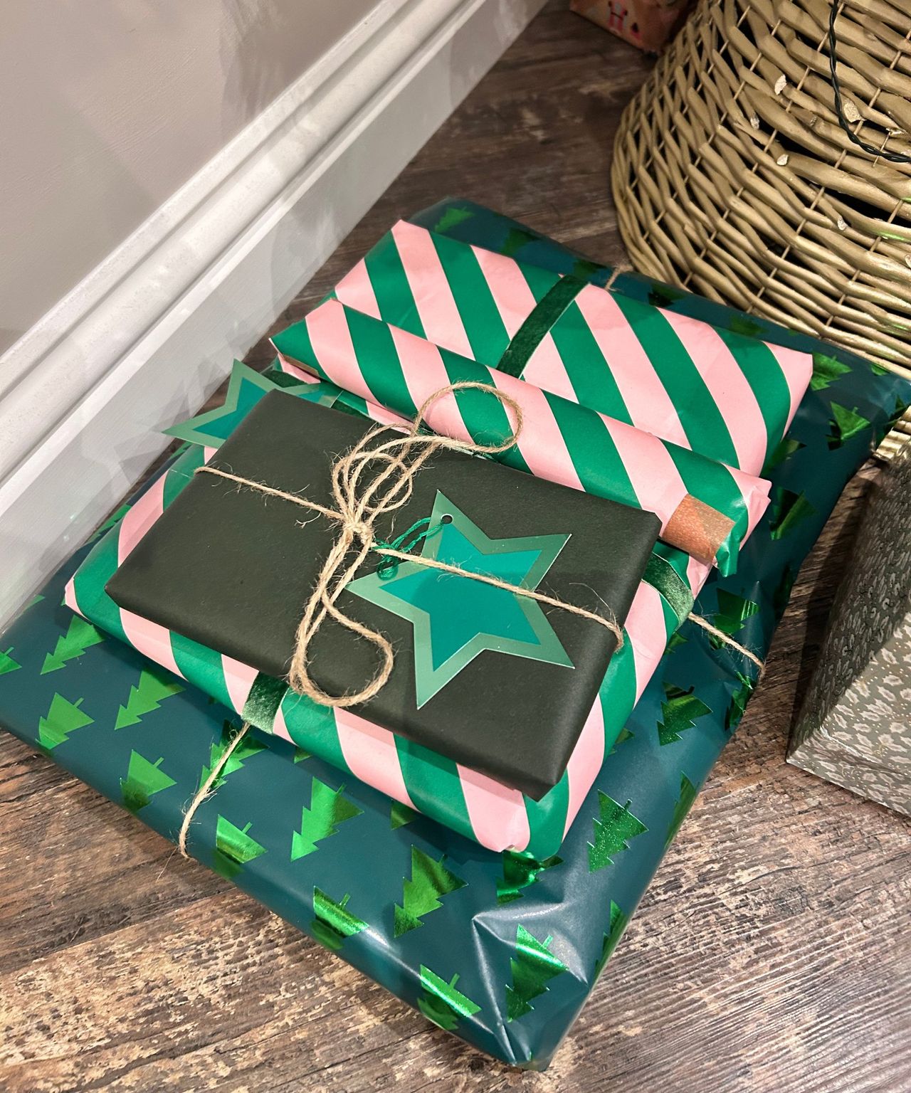 Colorful green and pink Christmas wrapping with green start and brown ribbon