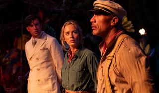 Jack Whitehall Emily Blunt and Dwayne Johnson standing mysteriously by torchlight in Jungle Cruise.
