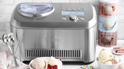 Breville Smart Scoop Ice Cream Maker on a countertop with ice cream around it in tubs and bowls