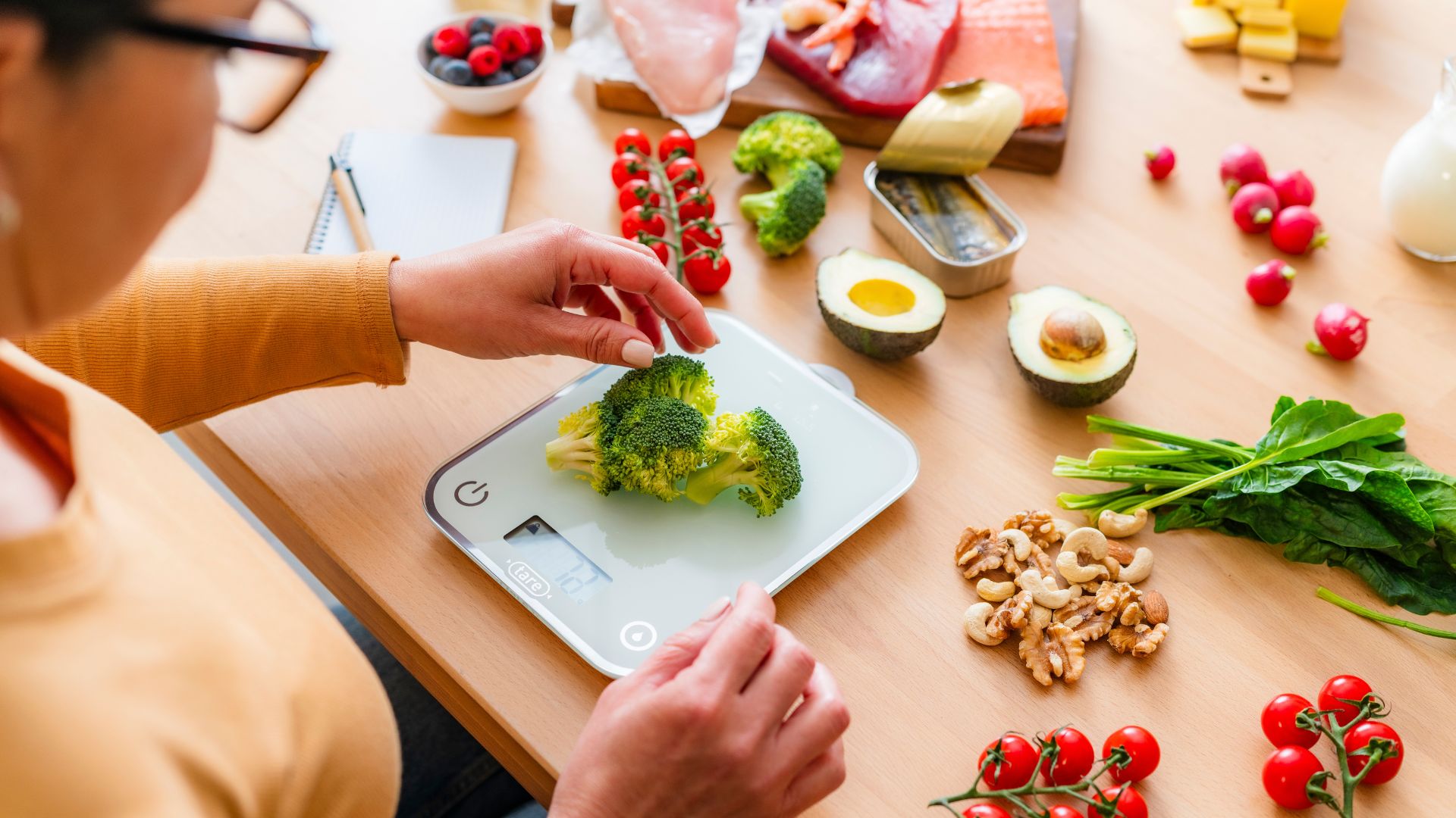 Woman measuring the weight of chopped veggies on a digital scale