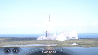 a black and white spacex rocket launches into a blue sky