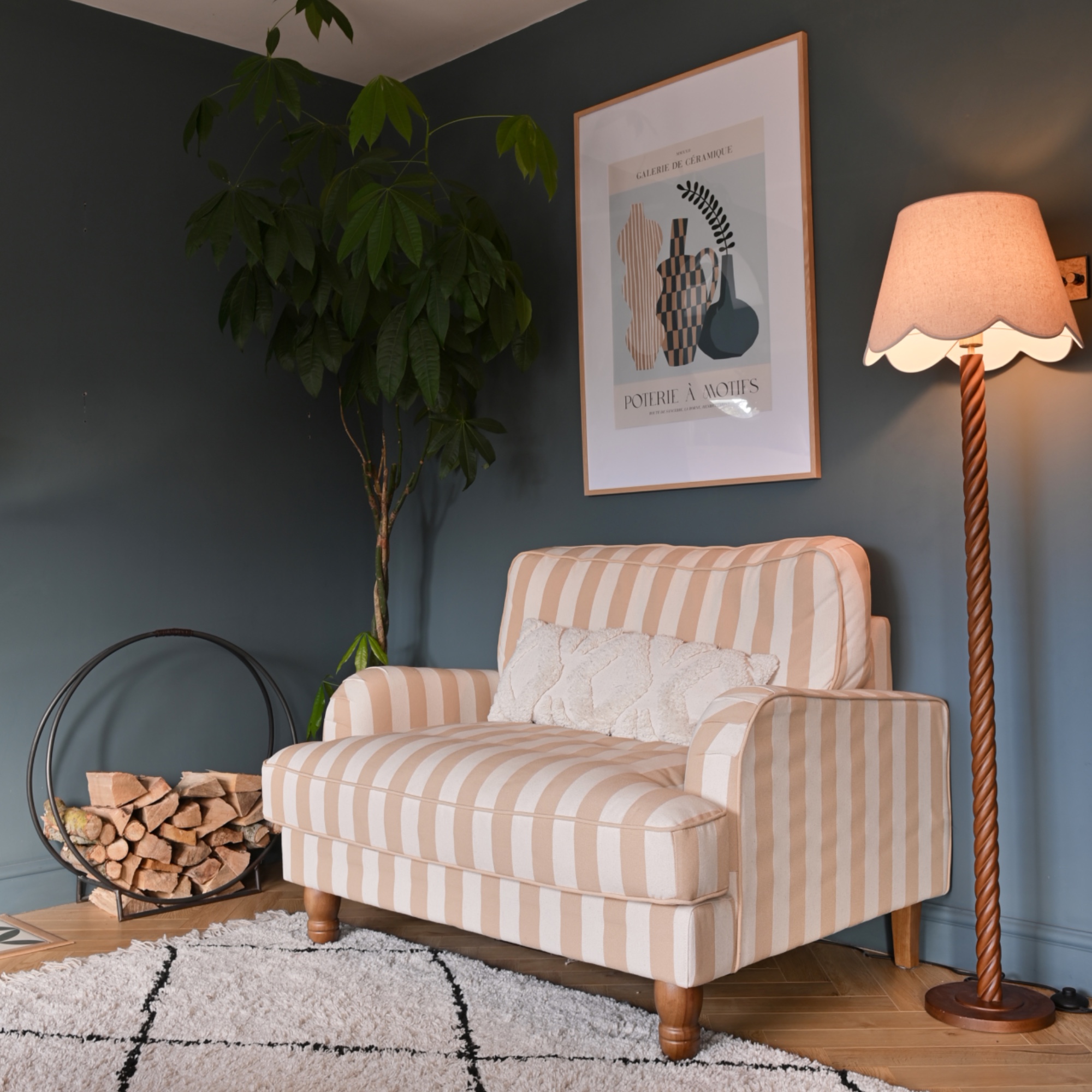 blue living room with stripe armchair, floor lamp, artwork, rug