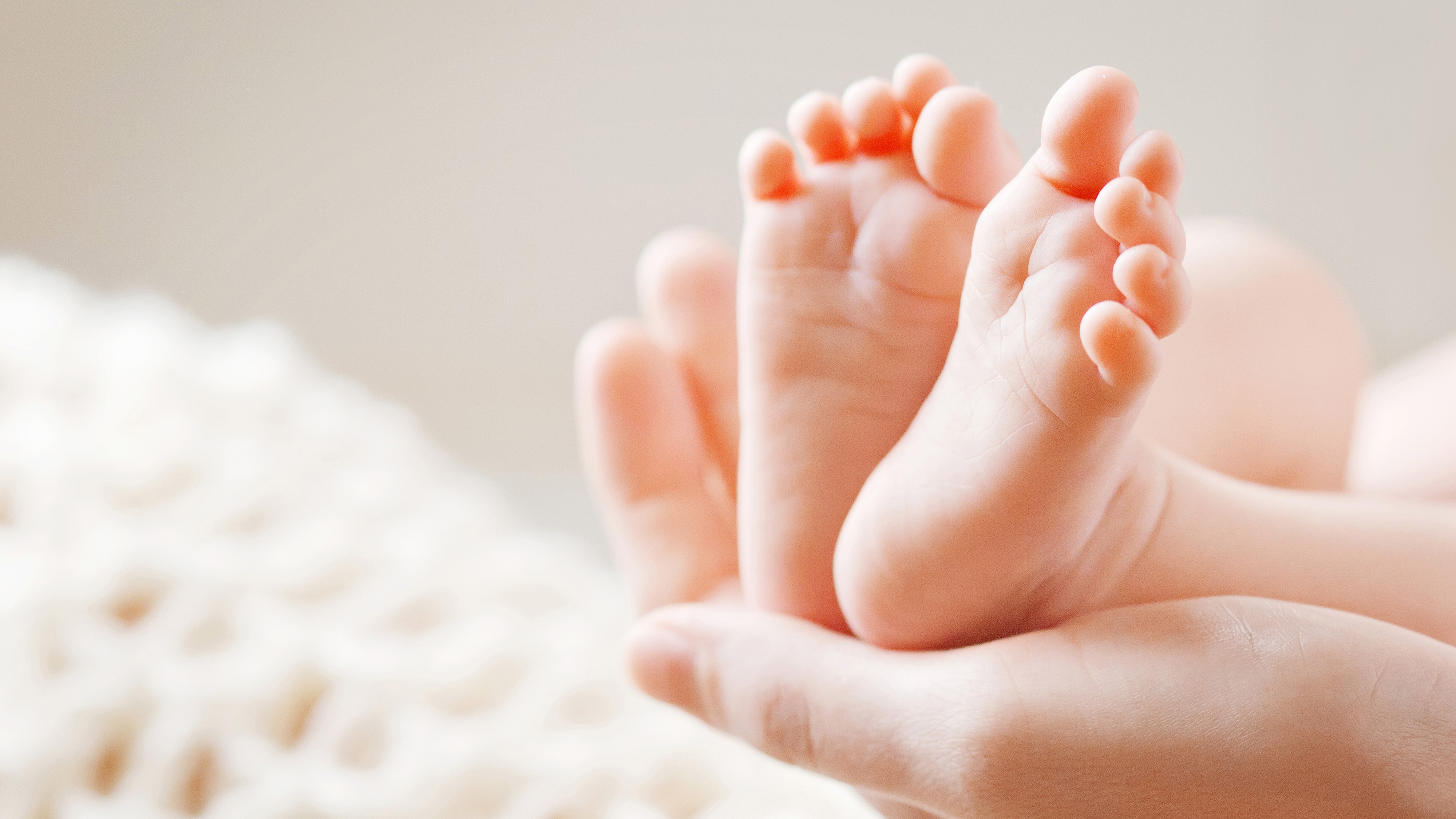 baby feet being held in a hand