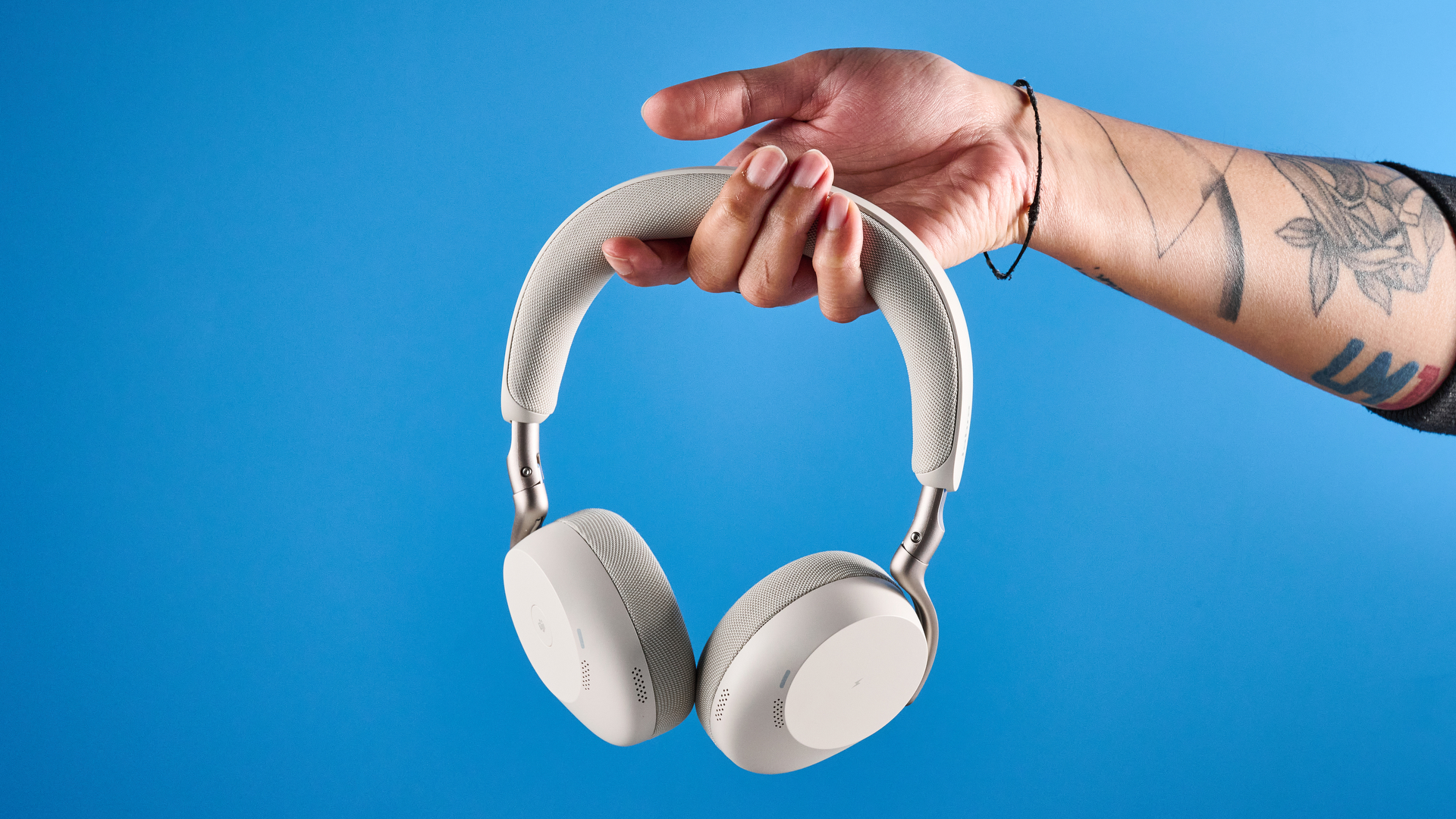 Jabras Evolve3 75 conferencing headset in hand against a blue background
