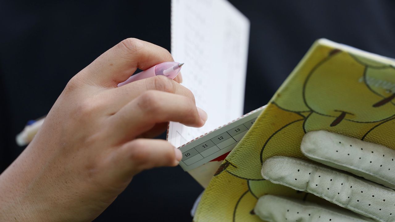 female golfer filling in a scorecard