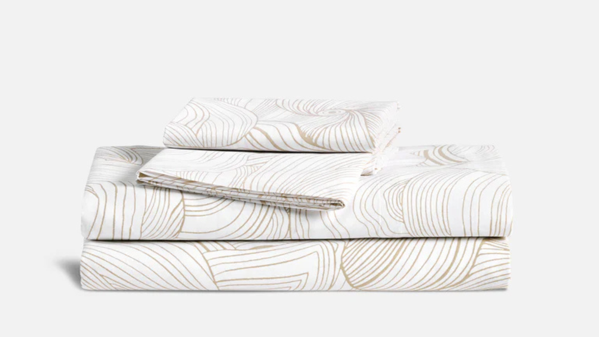Brooklinen Luxe Sateen Core Sheet set folded and stacked against a neutral background