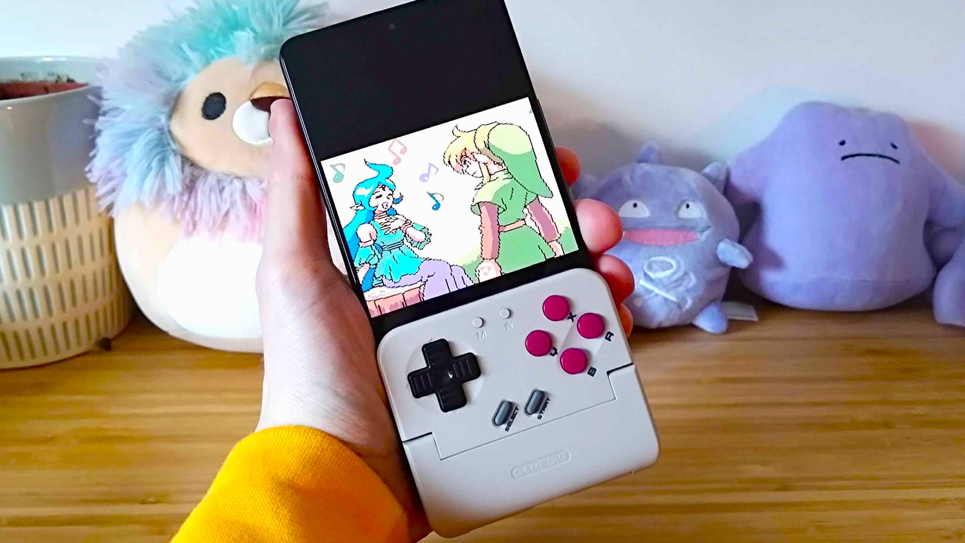 Hand holding Asus ROG Phone 8 with Gamesir Pocket Taco attached and Zelda Oracle of Ages cutscene on screen.