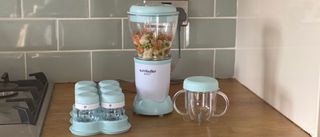 Nutribullet Baby on a kitchen countertop filled with buttersquash and surrounded by its accessories