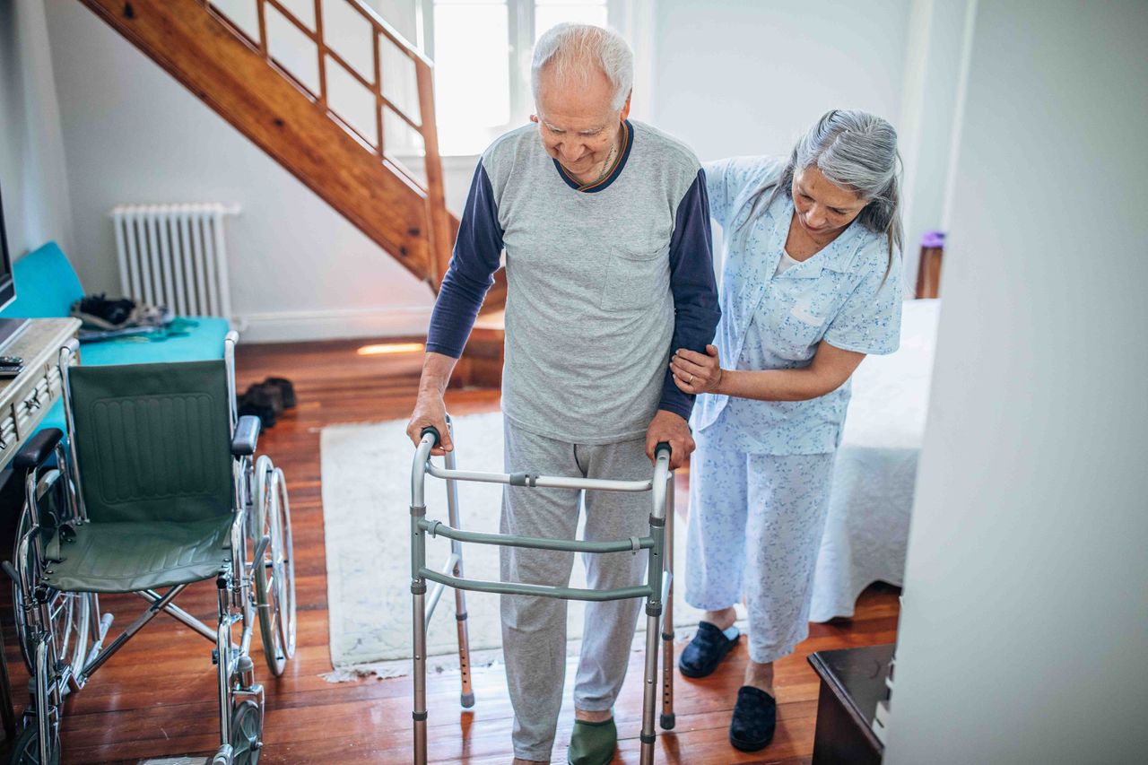 woman helping a man using a walker