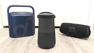 Bose, Ankers Soundcore and JBL speakers group together on a tiled floor