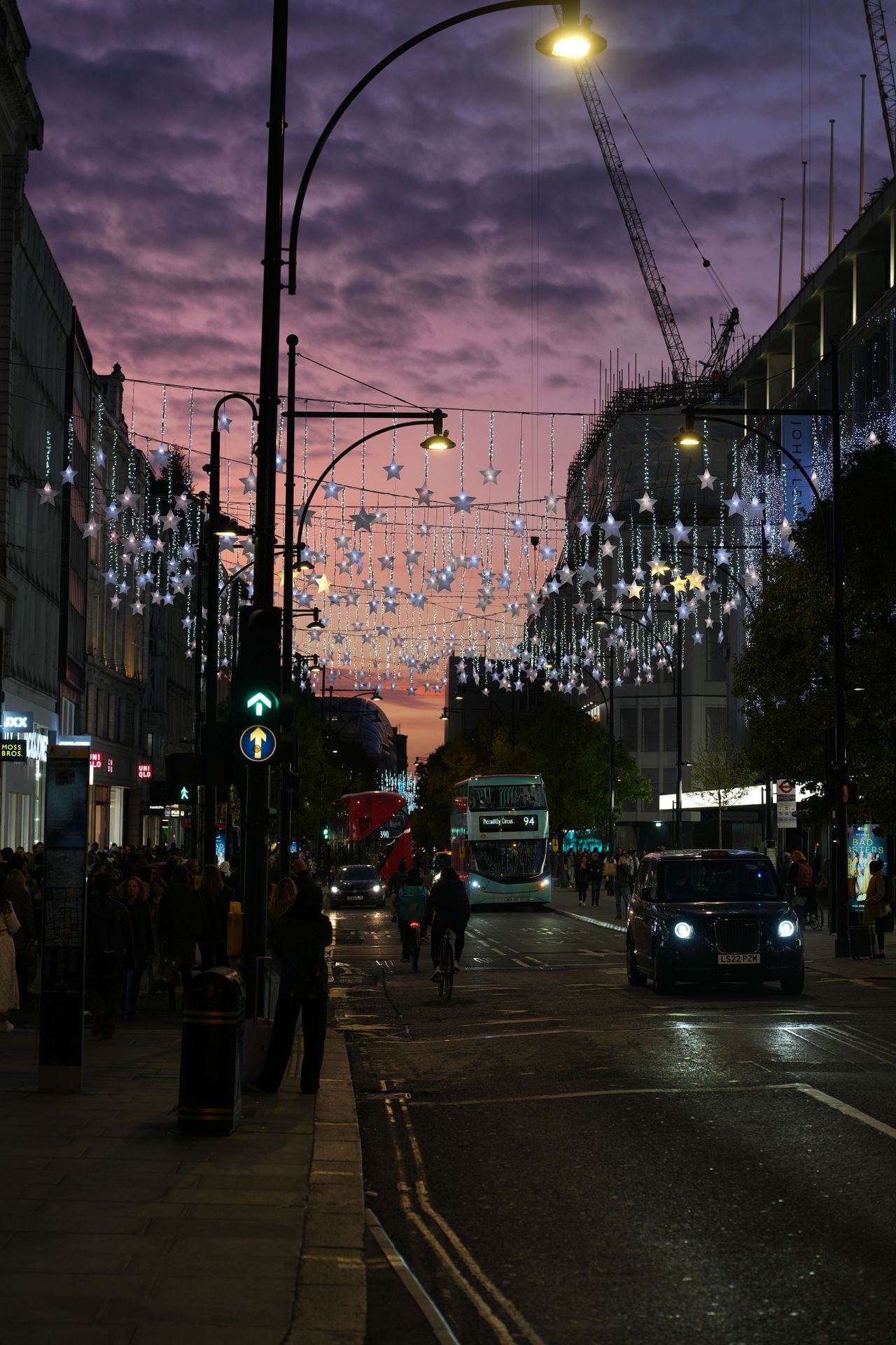 View down Oxford Street in London with Christmas hanging above the road in front of an orange sunset