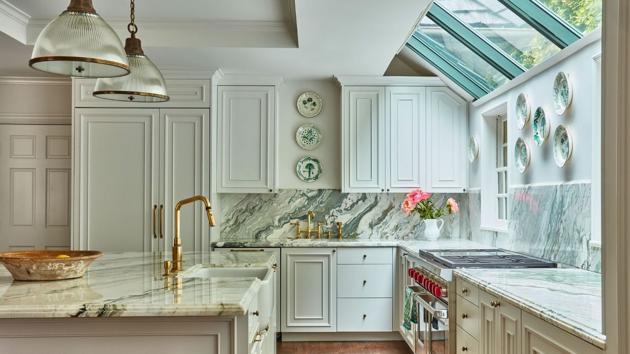 kitchen island with large pendants sloping rooflights, cream cabinets with marble counters