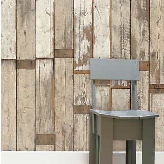 Wooden chair in front of wooden wallpaper and white skirting