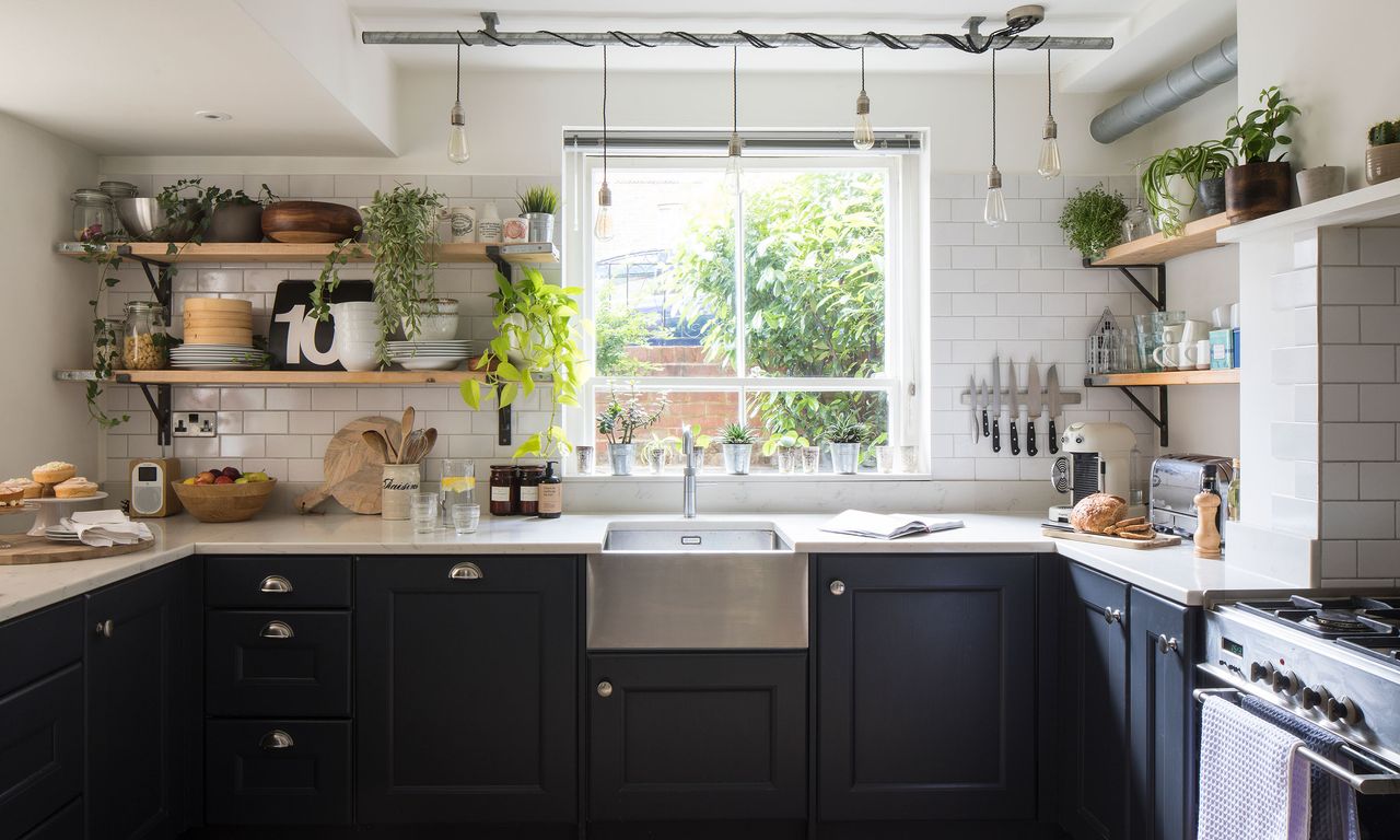 Navy kitchen cabinets with white brick tiles, butler sink, industrial open shelving