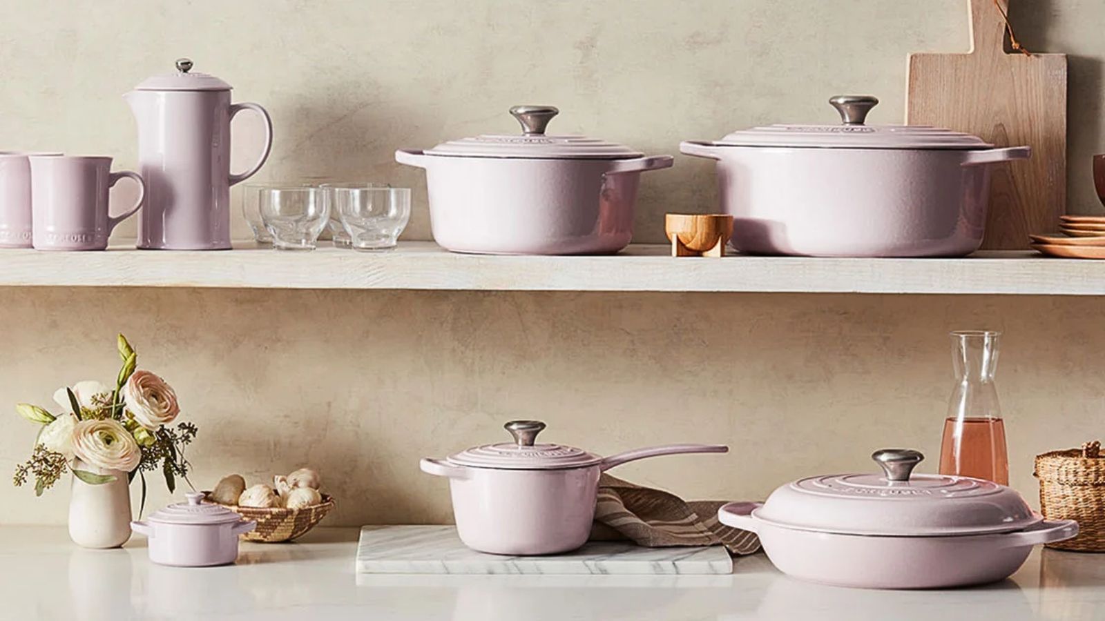 The complete Le Creuset Shallot set of pans and lids across a countertop and shelf. 