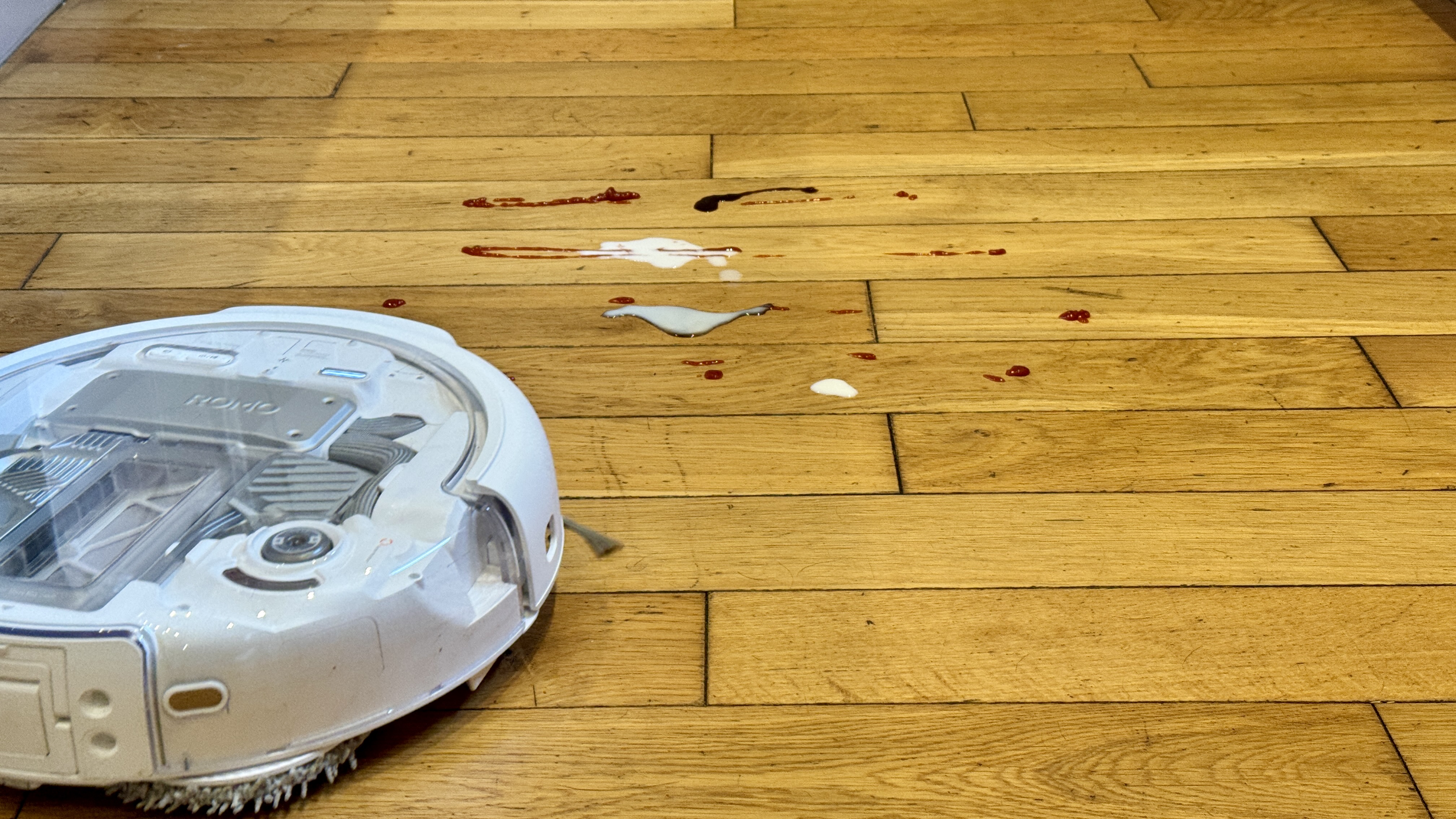 DJI Romo P robot vacuum about to mop milk from hard floor