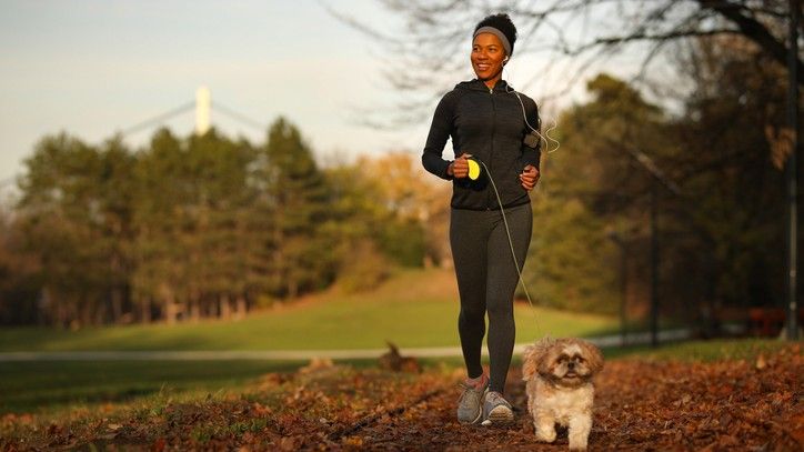 A woman running with her dog in a park