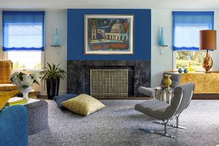 Mid-century modern living room with blue curtains and blue feature wall